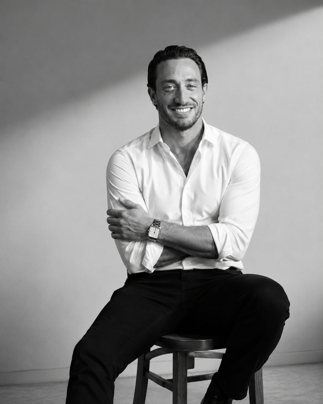 Maxime Cividini assis sur une chaise, sourire face caméra